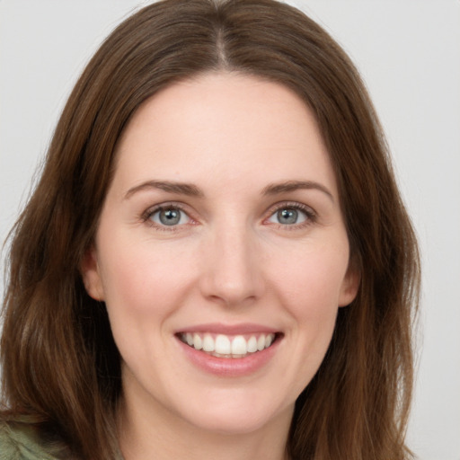 Joyful white young-adult female with long  brown hair and green eyes