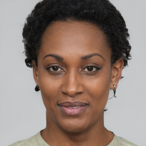 Joyful black young-adult female with short  black hair and brown eyes