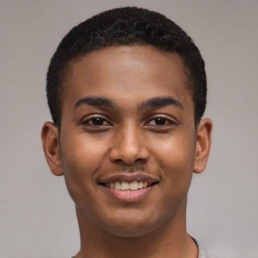 Joyful black young-adult male with short  brown hair and brown eyes