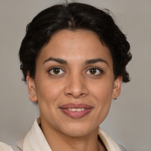 Joyful latino adult female with short  brown hair and brown eyes