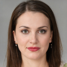 Joyful white young-adult female with long  brown hair and green eyes