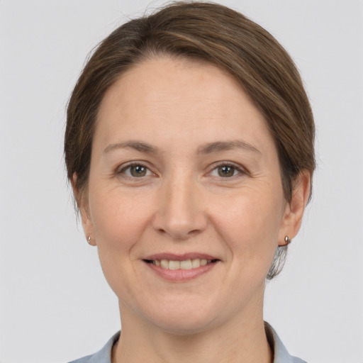 Joyful white adult female with medium  brown hair and grey eyes