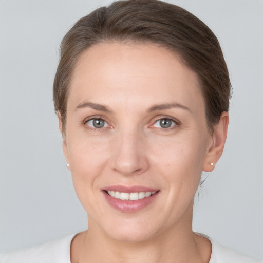 Joyful white young-adult female with short  brown hair and grey eyes