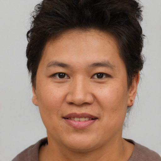Joyful asian adult female with short  brown hair and brown eyes