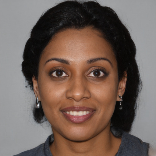 Joyful black young-adult female with medium  black hair and brown eyes