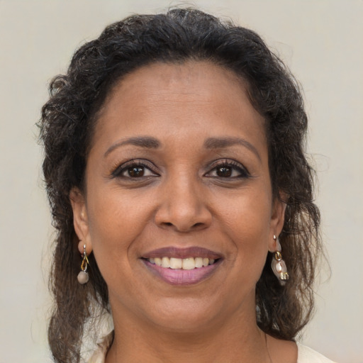 Joyful black adult female with long  brown hair and brown eyes