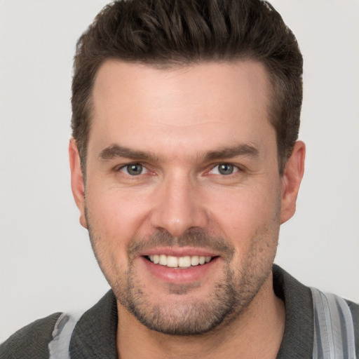 Joyful white adult male with short  brown hair and grey eyes