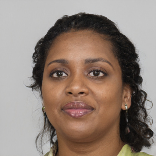 Joyful black adult female with long  black hair and brown eyes