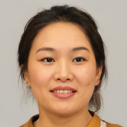 Joyful asian young-adult female with medium  brown hair and brown eyes