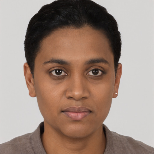 Joyful black young-adult female with short  black hair and brown eyes