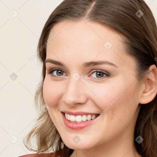 Joyful white young-adult female with long  brown hair and blue eyes