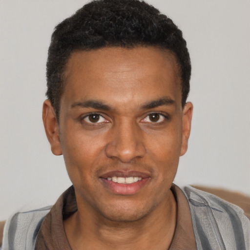 Joyful black young-adult male with short  black hair and brown eyes