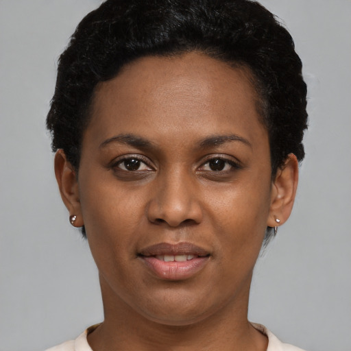 Joyful black young-adult female with short  brown hair and brown eyes