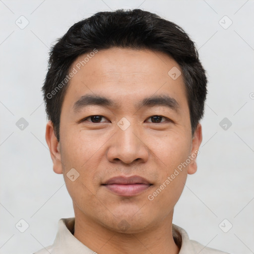 Joyful asian young-adult male with short  black hair and brown eyes