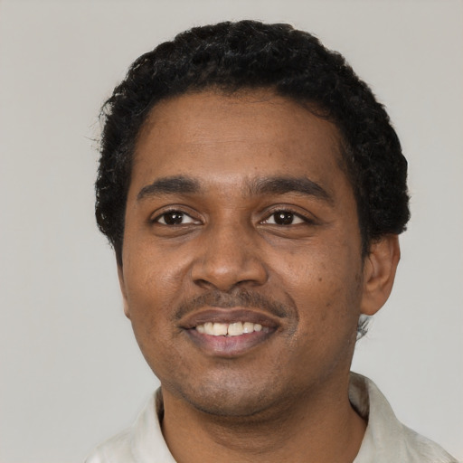 Joyful black young-adult male with short  black hair and brown eyes