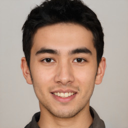 Joyful latino young-adult male with short  brown hair and brown eyes