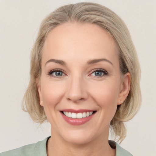 Joyful white adult female with medium  brown hair and grey eyes