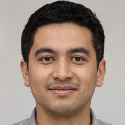 Joyful latino young-adult male with short  black hair and brown eyes