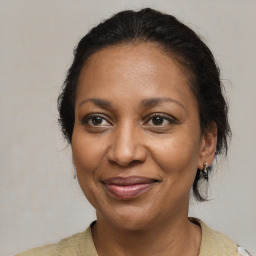 Joyful black adult female with medium  brown hair and brown eyes