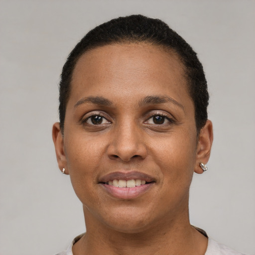 Joyful black young-adult female with short  black hair and brown eyes