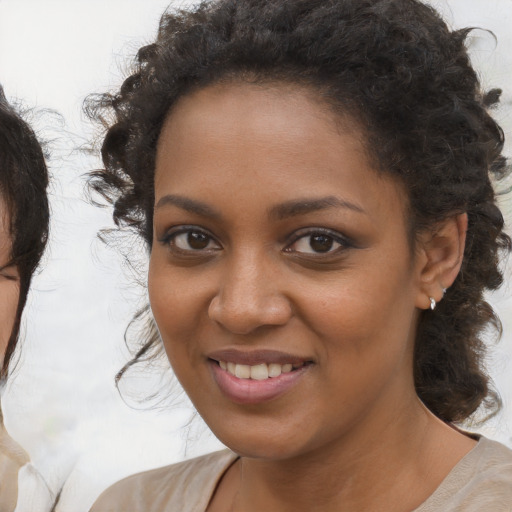 Joyful black young-adult female with medium  brown hair and brown eyes