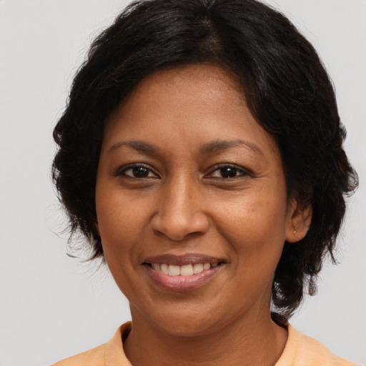Joyful black adult female with medium  brown hair and brown eyes