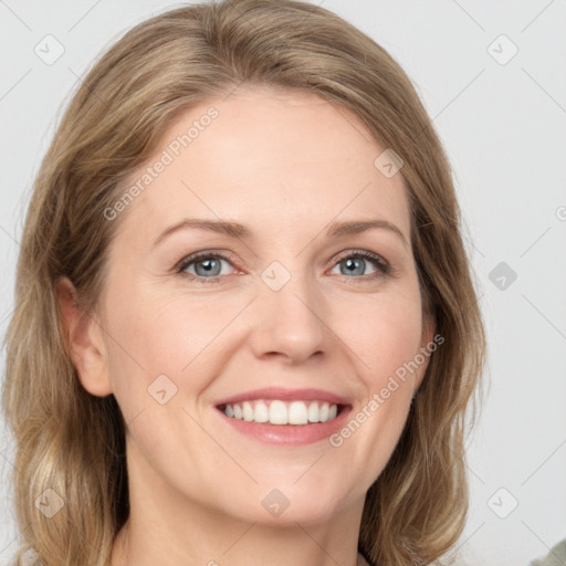 Joyful white adult female with medium  brown hair and green eyes