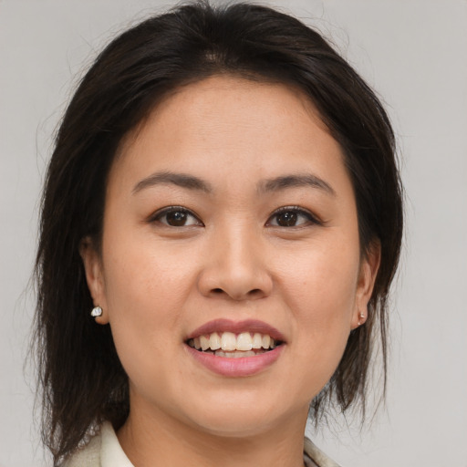 Joyful asian young-adult female with medium  brown hair and brown eyes