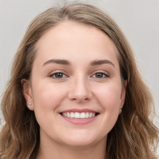 Joyful white young-adult female with long  brown hair and blue eyes