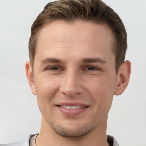 Joyful white young-adult male with short  brown hair and grey eyes