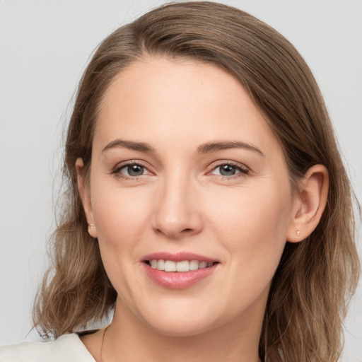 Joyful white young-adult female with long  brown hair and grey eyes