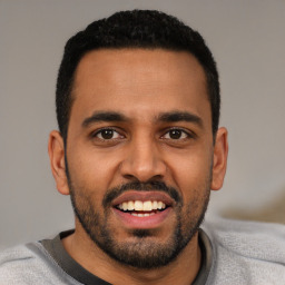 Joyful black young-adult male with short  black hair and brown eyes