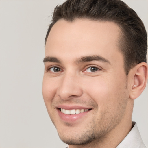 Joyful white young-adult male with short  brown hair and brown eyes