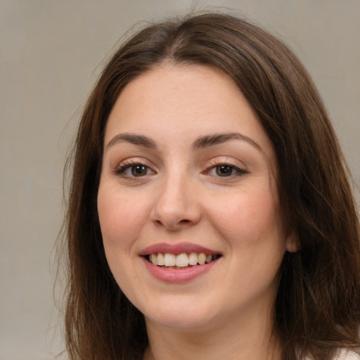 Joyful white young-adult female with long  brown hair and brown eyes