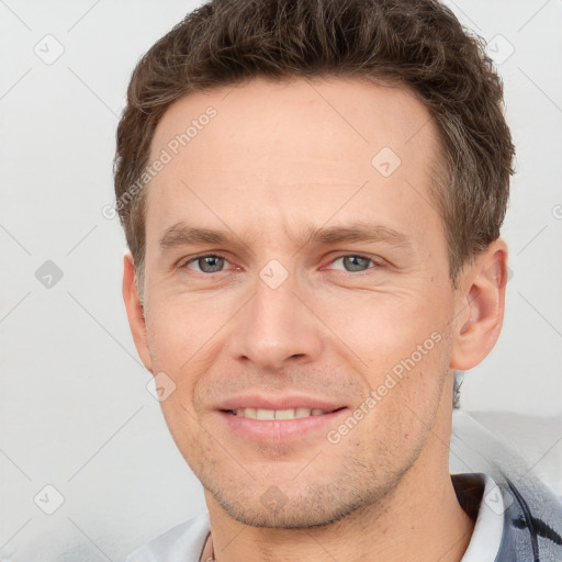 Joyful white adult male with short  brown hair and grey eyes