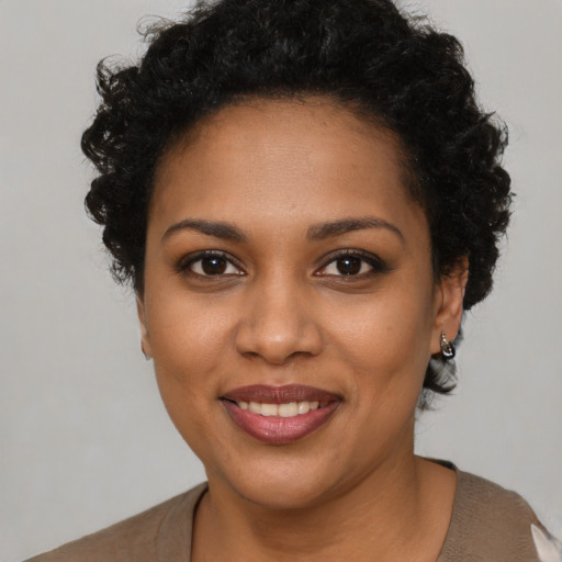Joyful black young-adult female with short  brown hair and brown eyes