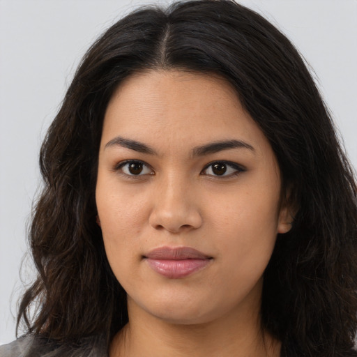 Joyful latino young-adult female with long  brown hair and brown eyes