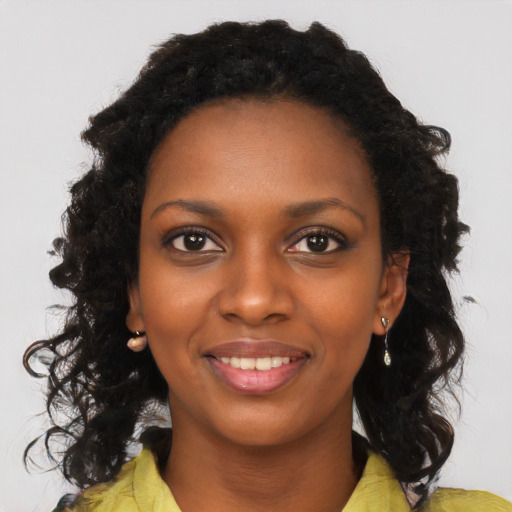 Joyful black young-adult female with long  black hair and brown eyes