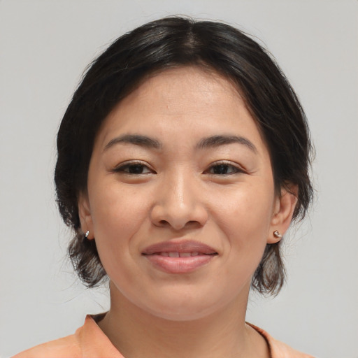Joyful asian young-adult female with medium  brown hair and brown eyes