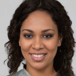 Joyful black young-adult female with long  brown hair and brown eyes