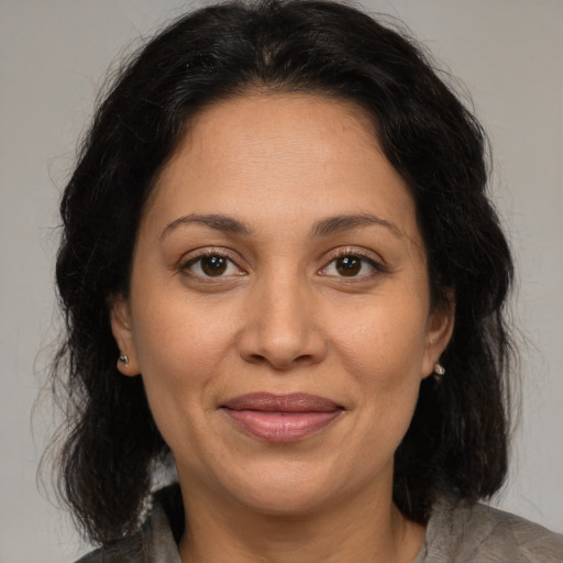 Joyful latino adult female with medium  brown hair and brown eyes