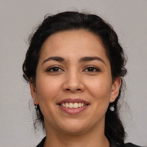 Joyful latino young-adult female with medium  brown hair and brown eyes