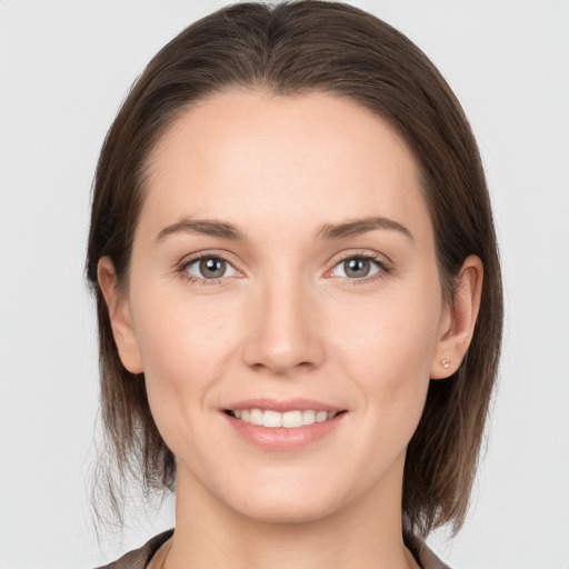 Joyful white young-adult female with medium  brown hair and grey eyes