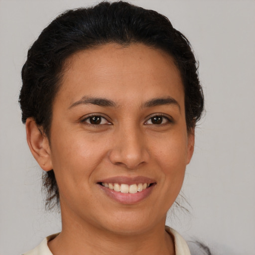 Joyful latino young-adult female with short  brown hair and brown eyes