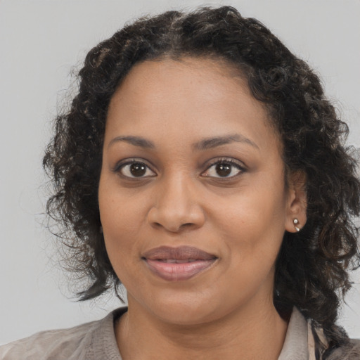 Joyful black young-adult female with long  brown hair and brown eyes