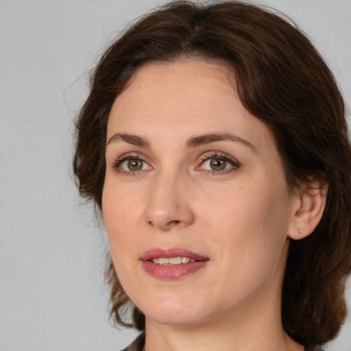 Joyful white adult female with medium  brown hair and brown eyes