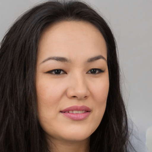 Joyful asian young-adult female with long  brown hair and brown eyes