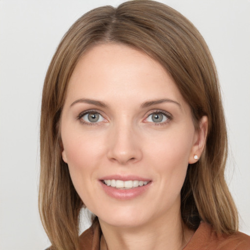 Joyful white young-adult female with long  brown hair and blue eyes