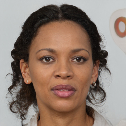 Joyful black adult female with medium  brown hair and brown eyes