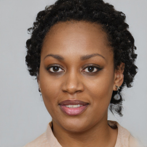 Joyful black young-adult female with medium  black hair and brown eyes